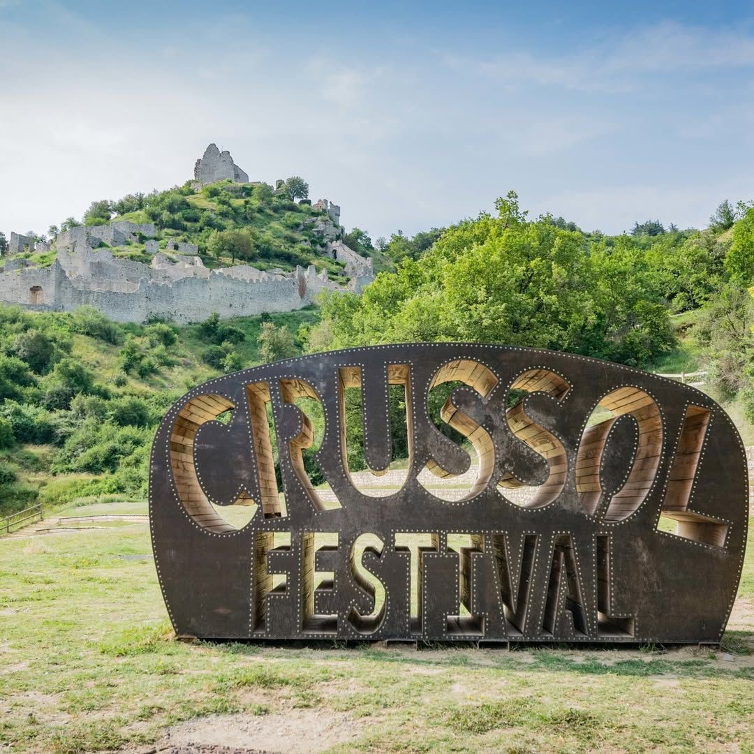 Le panneau emblématique du Crussol Festival devant les ruines du château